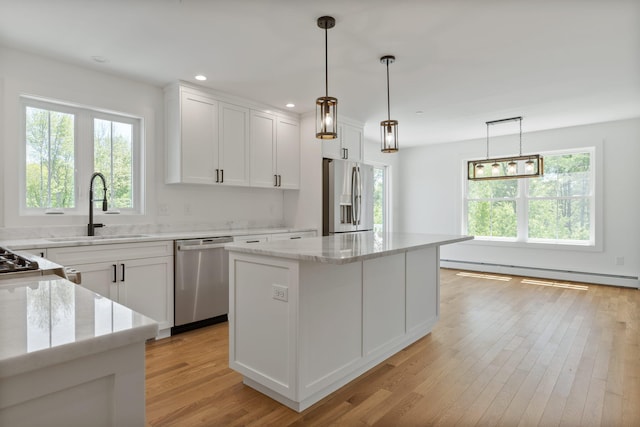 kitchen with a baseboard heating unit, light hardwood / wood-style floors, white cabinetry, a kitchen island, and appliances with stainless steel finishes