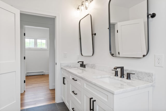 bathroom featuring vanity, hardwood / wood-style floors, and a baseboard heating unit