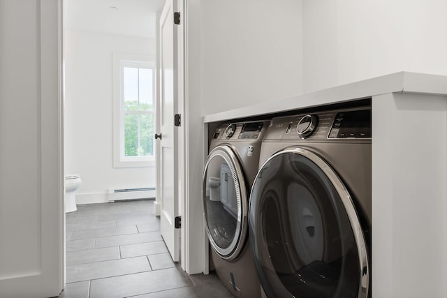 washroom with light tile patterned floors, baseboard heating, and independent washer and dryer