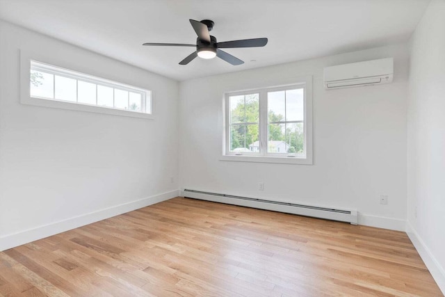 spare room with a baseboard radiator, a wealth of natural light, light hardwood / wood-style flooring, and a wall mounted air conditioner