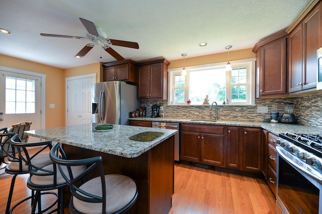 kitchen featuring light stone counters, stainless steel appliances, and plenty of natural light