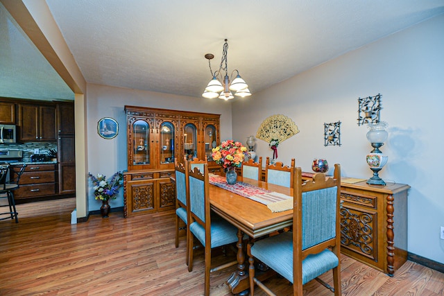 dining space with an inviting chandelier and light wood-type flooring