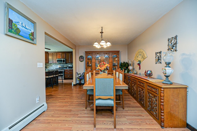 dining area with light hardwood / wood-style floors, a notable chandelier, and baseboard heating