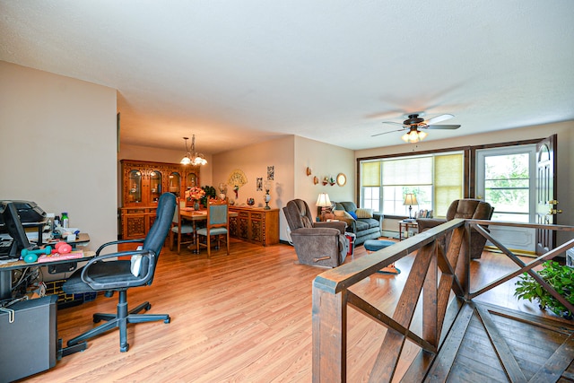 living room with ceiling fan with notable chandelier and light wood-type flooring