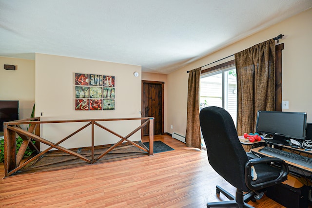 home office with a baseboard radiator and light wood-type flooring