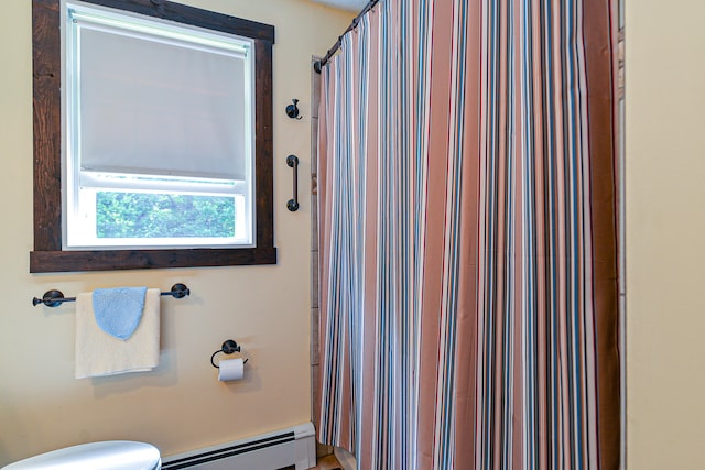 bathroom with toilet, a baseboard heating unit, and a shower with shower curtain