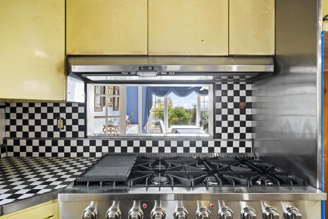 kitchen with stainless steel stove and tasteful backsplash