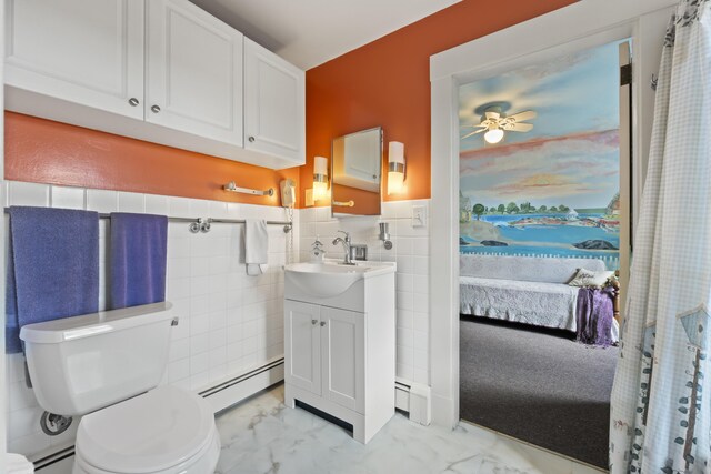 bathroom featuring tile walls, a baseboard heating unit, vanity, and toilet