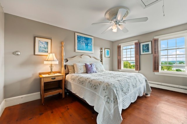 bedroom featuring ceiling fan, baseboard heating, and dark wood-type flooring