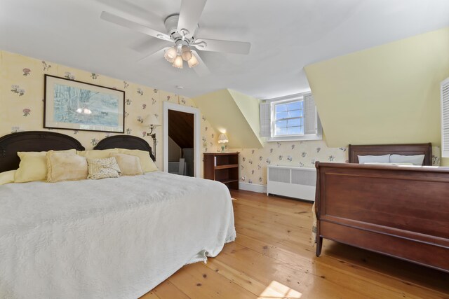 bedroom with radiator heating unit, wood-type flooring, and ceiling fan