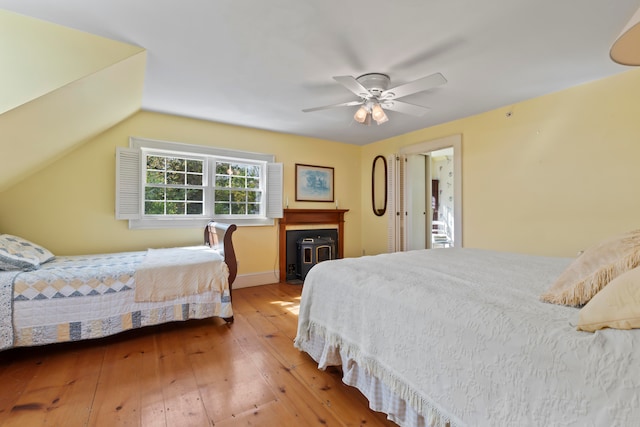 bedroom with ceiling fan, vaulted ceiling, and hardwood / wood-style floors