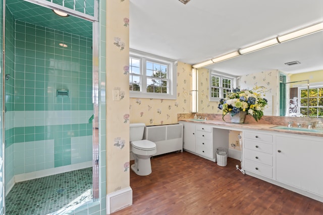 bathroom featuring wood-type flooring, walk in shower, radiator heating unit, vanity, and toilet