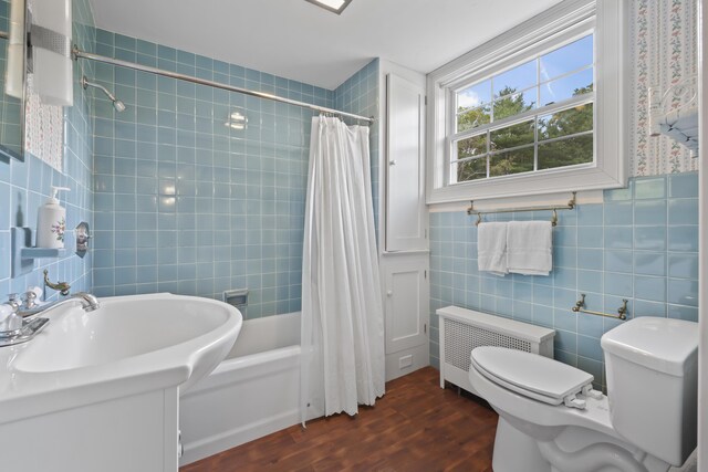 full bathroom with toilet, radiator heating unit, shower / tub combo, tile walls, and hardwood / wood-style floors