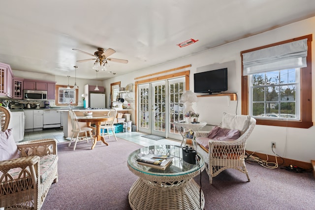 living room with light carpet, ceiling fan, and sink