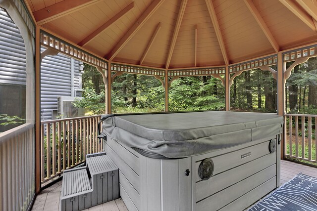 wooden terrace featuring a gazebo and a hot tub