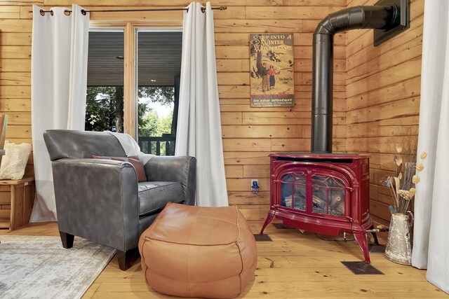 sitting room featuring a wood stove and light hardwood / wood-style floors