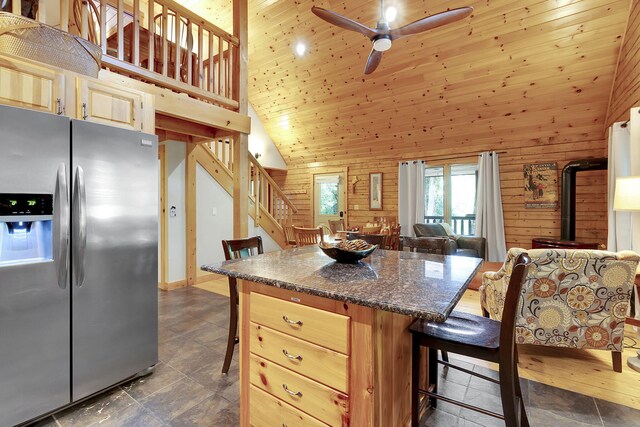 kitchen with stainless steel fridge, light brown cabinets, and high vaulted ceiling