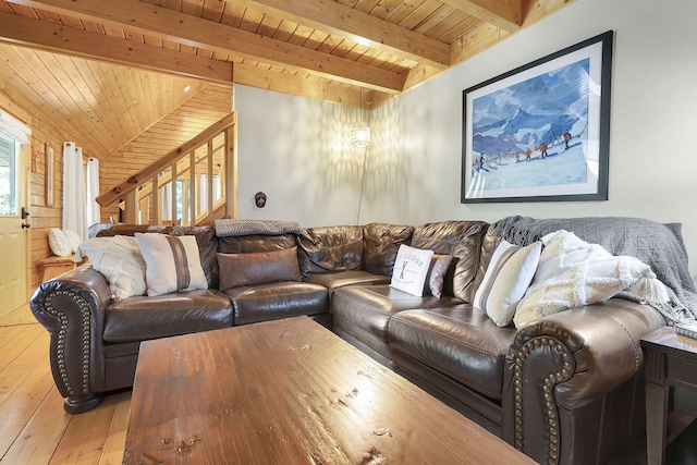 living room featuring beamed ceiling, light hardwood / wood-style flooring, wood walls, and wood ceiling