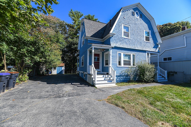 view of front property featuring a storage shed and a front lawn