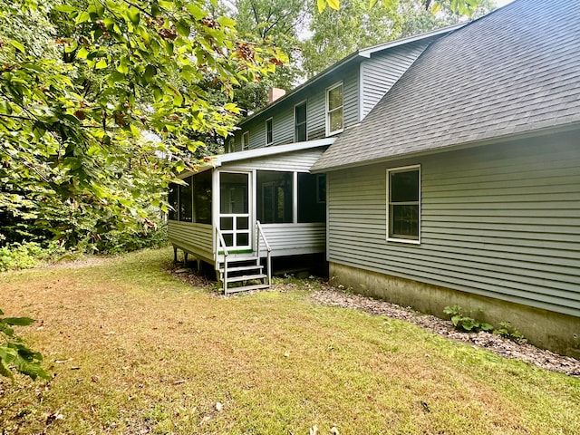 rear view of property featuring a sunroom and a yard