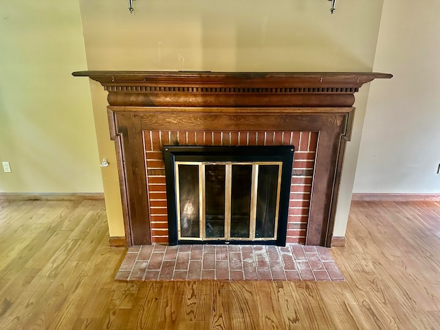 details featuring hardwood / wood-style floors and a brick fireplace