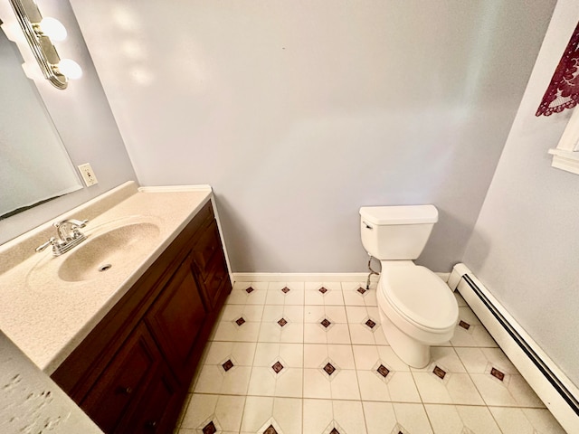 bathroom featuring a baseboard heating unit, tile patterned flooring, vanity, and toilet