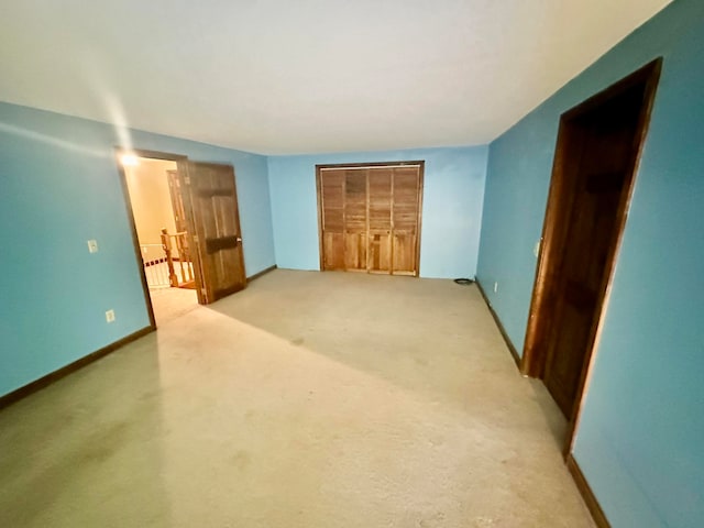 unfurnished bedroom with light carpet, a closet, and radiator heating unit