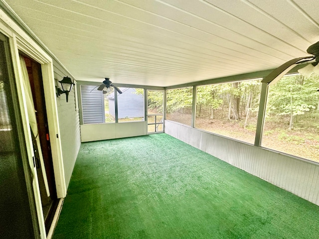 unfurnished sunroom featuring ceiling fan and a healthy amount of sunlight