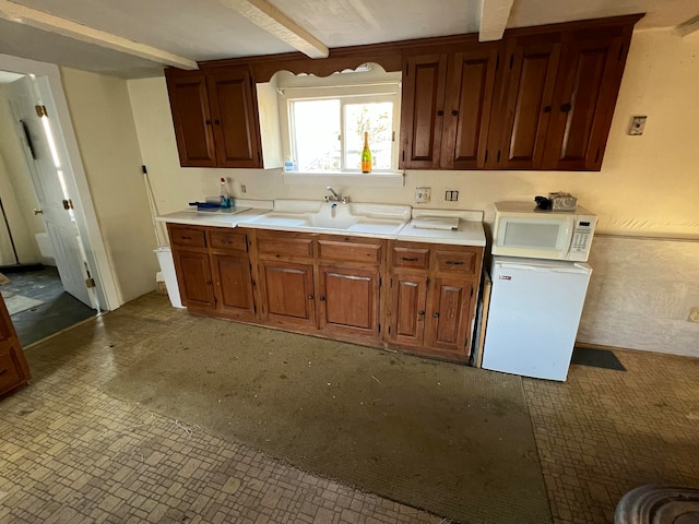 kitchen with beamed ceiling and sink