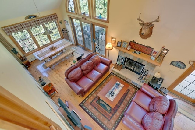 living room featuring wood-type flooring, a high ceiling, and a healthy amount of sunlight