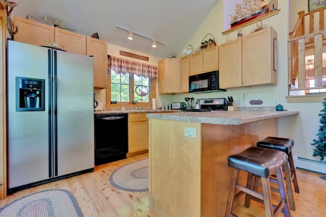 kitchen featuring a kitchen breakfast bar, light hardwood / wood-style floors, vaulted ceiling, light brown cabinets, and black appliances