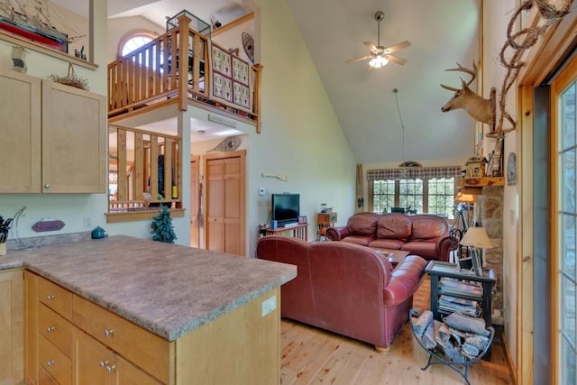 kitchen with ceiling fan, light brown cabinetry, light hardwood / wood-style floors, and high vaulted ceiling