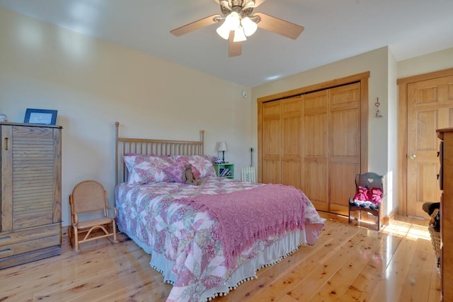 bedroom featuring ceiling fan, light wood-type flooring, and a closet