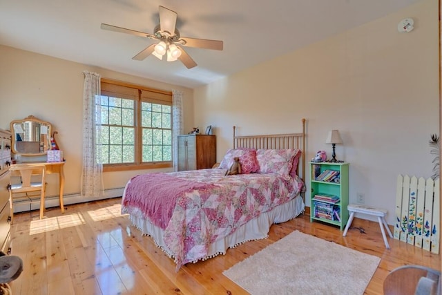 bedroom with ceiling fan, a baseboard heating unit, and wood-type flooring