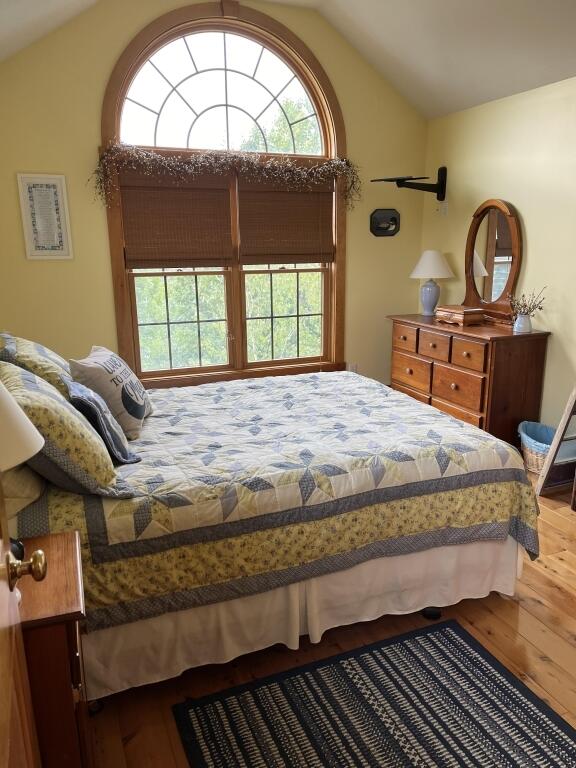 bedroom featuring lofted ceiling and hardwood / wood-style floors