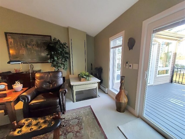 living area with carpet, a baseboard heating unit, and vaulted ceiling