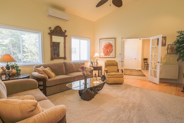 living room with a wall mounted air conditioner, light hardwood / wood-style flooring, french doors, and plenty of natural light