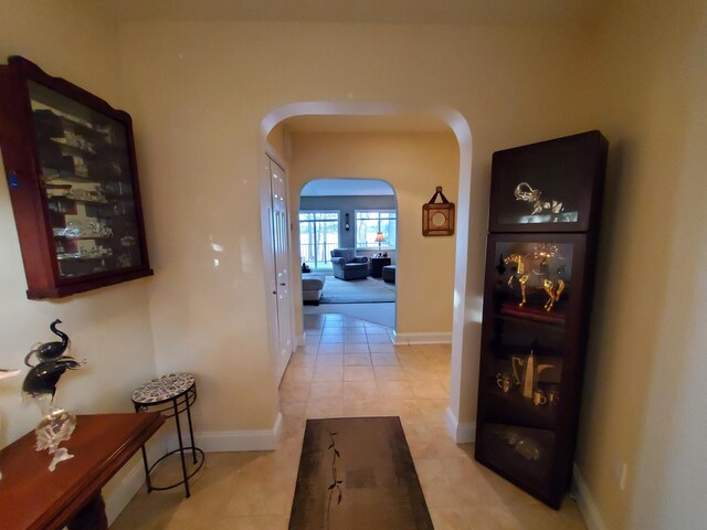 124 Collette Rd, Holden, ME 04429 - corridor with arched walkways, baseboards, and light tile patterned floors