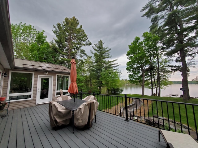 wooden deck with a yard and a water view