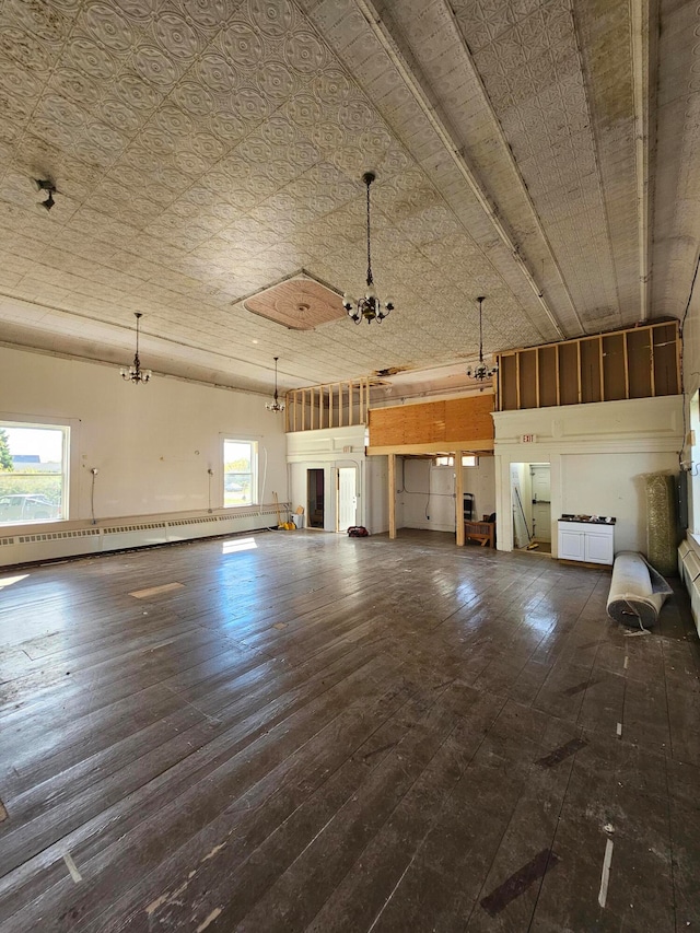 unfurnished living room with baseboard heating and dark hardwood / wood-style flooring