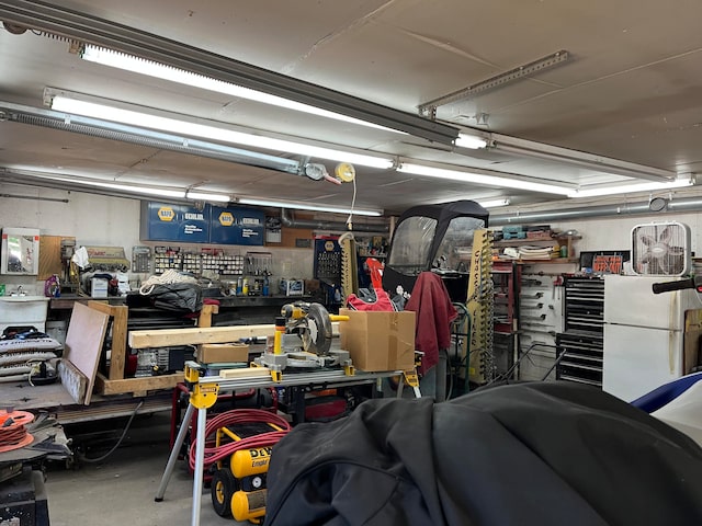 garage featuring a workshop area and white refrigerator