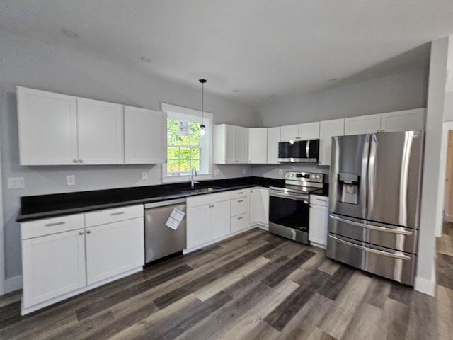 kitchen with dark wood-type flooring, appliances with stainless steel finishes, and white cabinets