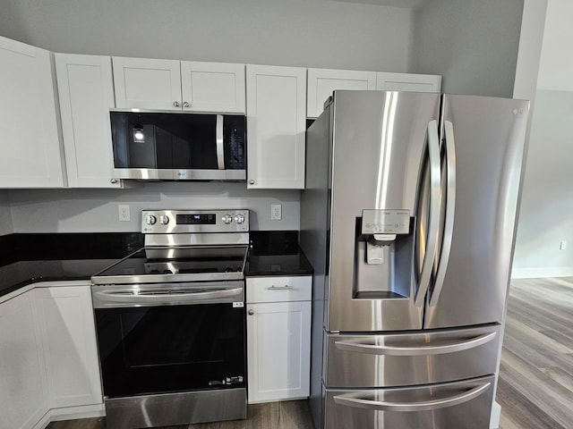 kitchen with white cabinets, stainless steel appliances, and light wood-type flooring