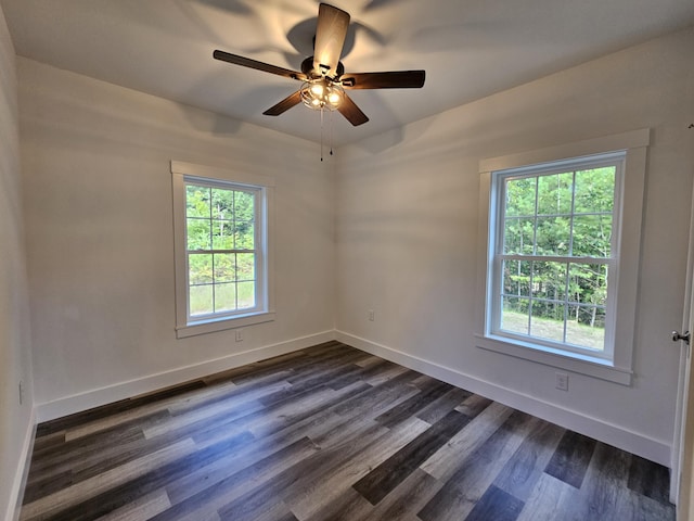 empty room with dark wood-style floors, ceiling fan, and baseboards