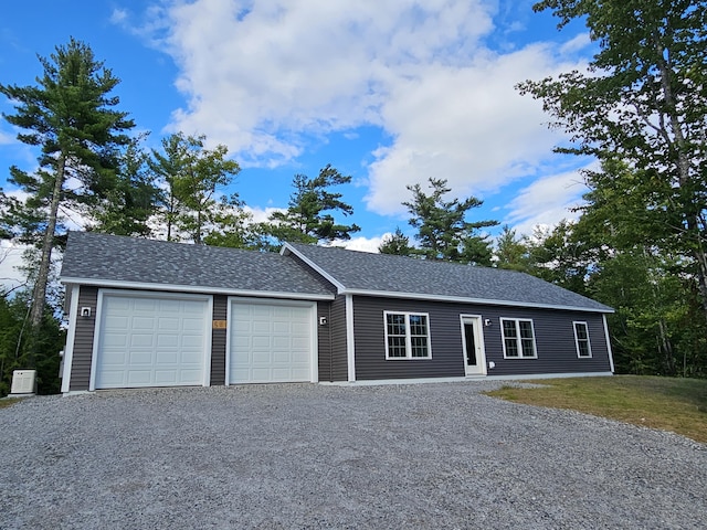 single story home with driveway, a garage, and roof with shingles