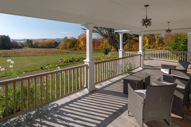 wooden terrace featuring a porch and a rural view