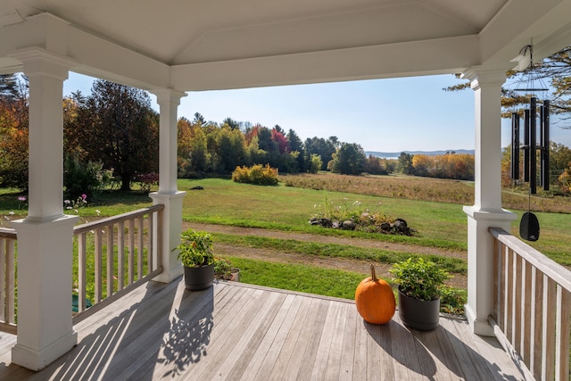 deck featuring a rural view and a lawn