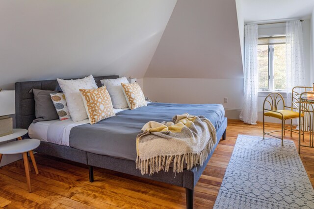 bedroom featuring lofted ceiling and hardwood / wood-style flooring