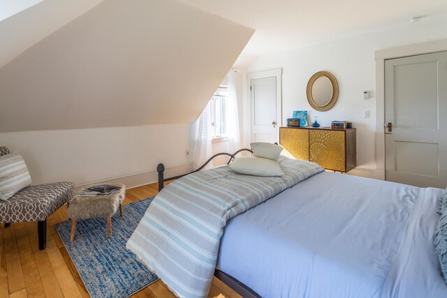 bedroom with lofted ceiling and light hardwood / wood-style flooring