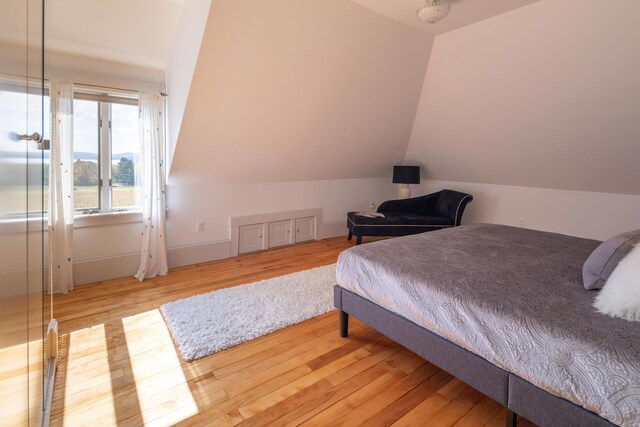 bedroom featuring light hardwood / wood-style floors and vaulted ceiling